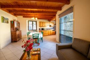 a living room with a table and a kitchen at L'oustal de lucie in Saint-Saturnin-de-Tartaronne