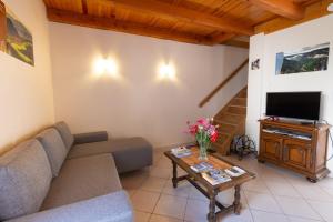 a living room with a couch and a tv at L'oustal de lucie in Saint-Saturnin-de-Tartaronne