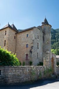 a large brick building with a stone wall at L'oustal de lucie in Saint-Saturnin-de-Tartaronne