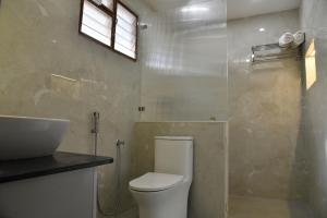 a bathroom with a toilet and a sink at Aadhya Abode Holiday Home in Kanyakumari +6 photos