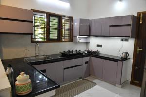 a kitchen with a sink and a counter top at Aadhya Abode Holiday Home in Kanyakumari