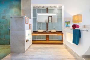 a bathroom with two sinks and a mirror at Luxurious 4BR Villa in Vairoa +17 photos