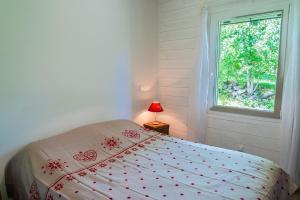 a bedroom with a bed and a window at La source du cellier 4/6 personnes in Saint-Jean-la-Fouillouse