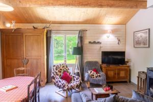a living room with a couch and a tv at La source du cellier 4/6 personnes in Saint-Jean-la-Fouillouse