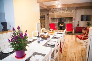 a living room with a long table and red chairs at Maison pierre de mercoeur in Le Malzieu-Ville
