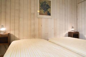 a bedroom with two beds and two lights on two tables at Maison pierre de mercoeur in Le Malzieu-Ville