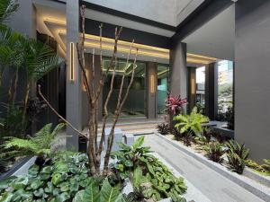 a garden in front of a building with plants at โรงแรมแชปเตอร์ หาดใหญ่ - Chapter Hotel Hatyai in Sathani Khlong Rian