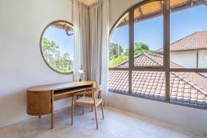 a desk in a room with a large window at Maison Boheme Modern Apartment & Villa with Pool in Sanur in Sanur
