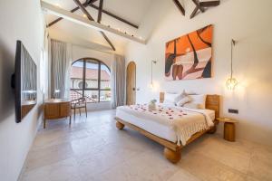 a bedroom with a large bed and a bathroom at Maison Boheme Modern Apartment & Villa with Pool in Sanur in Sanur