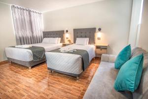 a hotel room with two beds and a couch at Samakuy Home Arequipa in Arequipa