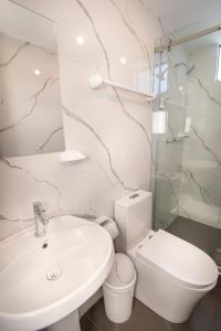 a white bathroom with a sink and a toilet at Samakuy Home Arequipa in Arequipa +31 photos