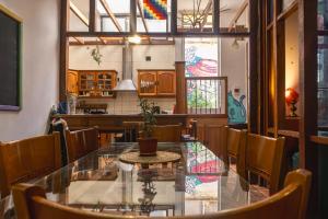 a dining room with a glass table and chairs at Gatalegre Hostel in Valparaíso