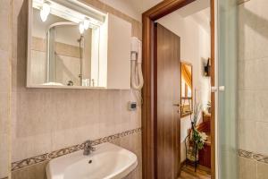y baño con lavabo y espejo. en Trastevere Rooms, en Roma