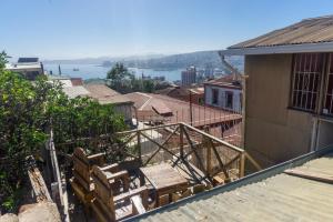 a balcony with chairs and a view of the water at Gatalegre Hostel in Valparaíso