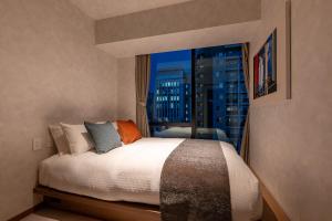 a bedroom with a bed with a view of a city at Hotel EN-YO in Tokyo