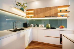 a kitchen with white cabinets and a sink at BRIO Ventura Apartment in Danang