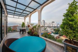 a balcony with a blue table and a view of the city at BRIO Ventura Apartment in Danang