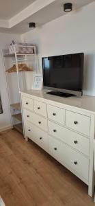 a white dresser with a television on top of it at Cozy Suite Kirchheim, Parkplatz, Nähe A8, Souterrain in Kirchheim unter Teck +13 photos