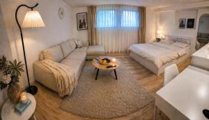 a living room with a couch and a bed at Cozy Suite Kirchheim, Parkplatz, Nähe A8, Souterrain in Kirchheim unter Teck