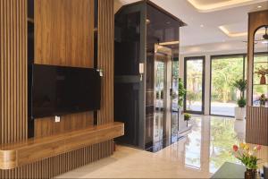 a living room with a television on a wall at La Mejor Homestay in Quang Tri