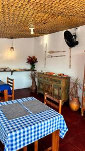 a kitchen with a table with a blue and white checkered table cloth at Pousada Angellus in Paraty