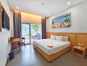 a bedroom with a bed and a desk and a window at The West Cove Hotel in Banten +33 photos