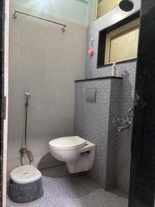 a small bathroom with a toilet and a shower at The Human Stay in Indore