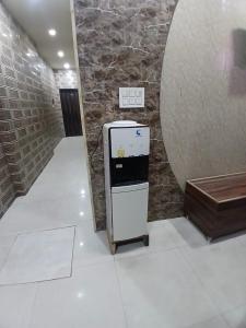 a small refrigerator in a room with a brick wall at Agam Homestay - Few Steps From golden temple in Amritsar