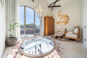a large bathroom with a tub in a room with a window at Maison Boheme Modern Apartment & Villa with Pool in Sanur in Sanur
