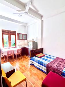 a bedroom with a bed and a table and a refrigerator at Studio Greenlands 2nd D-Battaramulla in Talangama South