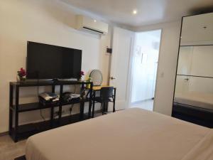 a bedroom with a bed and a flat screen tv at Scandi Villas Boracay by Simple Realty Management in Boracay
