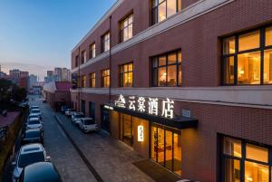 a building with cars parked in a parking lot at Shiershan · Yuntang Hotel in Qingdao