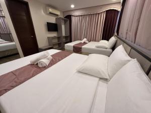 a hotel room with two beds and a television at Cambridge Guest House in Mandaue City