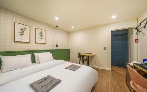 a bedroom with a large white bed with a blue door at My 24 Motel in Incheon