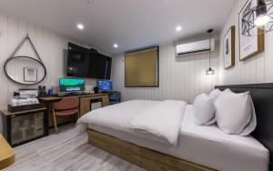 a bedroom with a bed and a desk with a computer at My 24 Motel in Incheon
