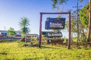a sign for a restaurant in a field at Posada Ña Arminda in Capitán Miranda