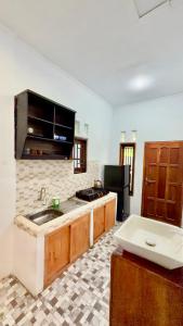 a kitchen with a sink and a stove at Trytan Gerupuk Homestay in Bumbang