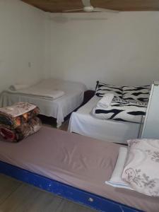a room with three beds in a room with at Posada Ña Arminda in Capitán Miranda