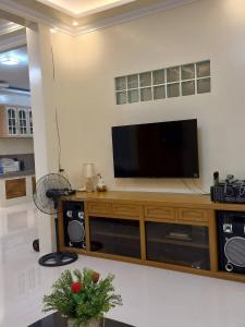 a living room with a flat screen tv on a entertainment center at Spacious Villa in Baclayon