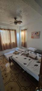 a bedroom with a large bed with a ceiling at White Beach Villa in Dauis