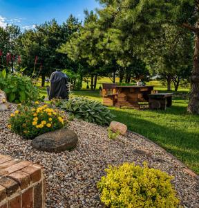a garden with flowers and a picnic table in a park at Pavasario Namai & SPA in Alytus