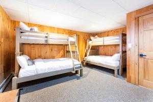 two bunk beds in a room with wooden walls at Mountain View Chalet Ski, Hot Tub, Firepit, Games in Lexington