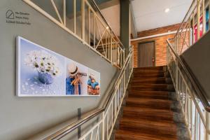 a hallway with stairs and a painting on the wall at BB House Rambuttri2 บีบี เฮ้าส์ รามบุตรี2 in Bangkok