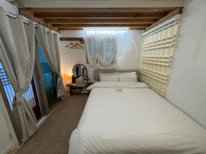 a bedroom with a large white bed and a window at Pungnam House in Jeonju