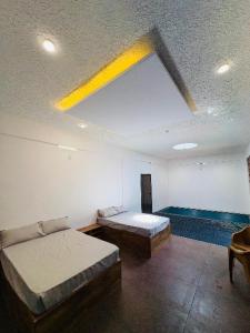 a room with two beds and a ceiling with a window at Deep Villa in Batheri