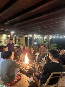 a group of people sitting around a fire at Khói Panorama in Dồng Văn