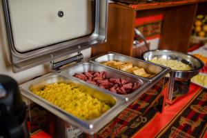 a buffet with many different types of food in trays at Quechua Hostal Recoleta in Cusco