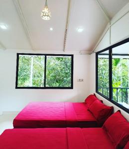 a large red bed in a room with windows at Deep Villa in Batheri