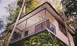 a house with a balcony and a tree at Deep Villa in Batheri