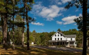a white house surrounded by trees at Pine Brook Manor in Sparrow Bush